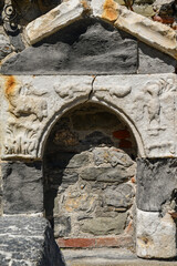 Close-up of ancient old stone and marble wall with engraved religious symbols, Porto Venere, La Spezia, Liguria, Italy