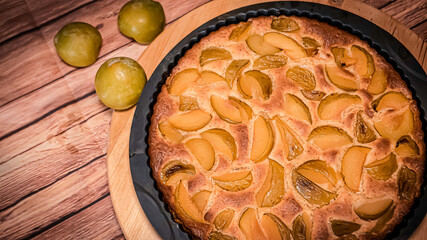 Fresh organic plum cake on the wooden table just made