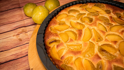 Fresh organic plum cake on the wooden table just made