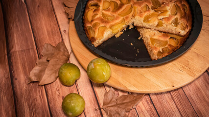 Fresh organic plum cake on the wooden table just made