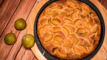 Fresh organic plum cake on the wooden table just made