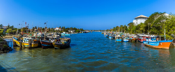A view of fishing boats moored at the entrance to the lagoon in Negombo, Sri Lanka © Nicola
