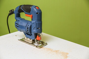 electric jigsaw is on cut board