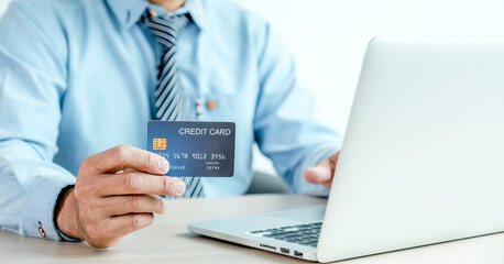 Businessman hand holding credit card to online shopping from home with laptop, payment e-commerce,...