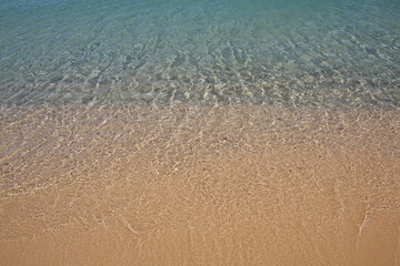 onda che si infrange su una spiaggia di sabbia
