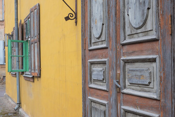 The facade of an old building with a green window frame.