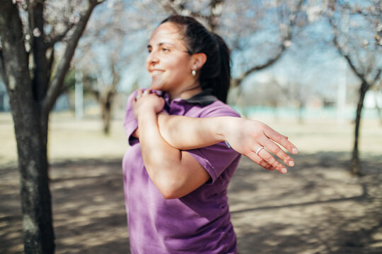 Mujer latina haciendo ejercicios debajo de los arboles