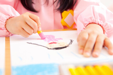 Obraz na płótnie Canvas クレヨンで絵を描く幼稚園児の手元