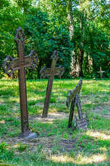 View of the broken and skewed cast iron crosses in the old cemetery