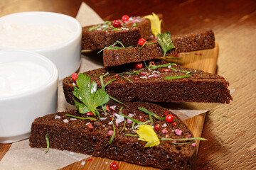Rye bread croutons sprinkled with pink pepper are on the plate