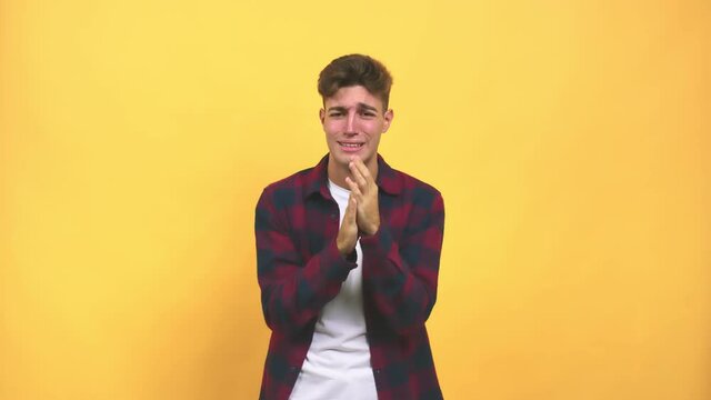 Young caucasian student man desperate and sad, crying inconsolably, is pessimistic and melancholy