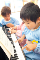 Fototapeta na wymiar ピアノを弾く幼稚園児
