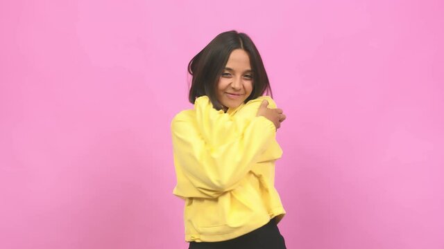 Young indian woman giving a hug, feeling of pride and happiness, affection towards yourself