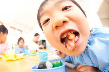 お弁当を食べる幼稚園児