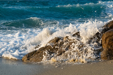 Sea water splashing on rocks in the Mesakti beach in Ikaria, Aegean Island in Greece