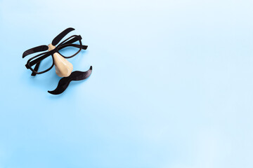Carnival mask with moustache, nose and glasses on blue background, copy space. Concept men's...