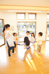 Fototapeta premium 輪になって踊る保育士と保育園児