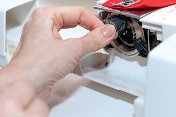 Handmade mask sewing from the fabric. Woman sews a mask from viruses, dust and germs