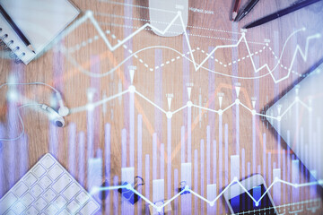 Multi exposure of forex graph hologram over desktop with phone. Top view. Mobile trade platform concept.