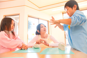 粘土で遊ぶ幼稚園児と幼稚園教諭