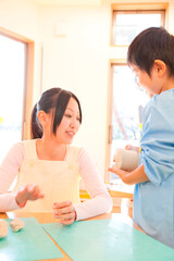 Fototapeta premium 粘土で遊ぶ幼稚園児と幼稚園教諭