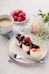 Fritters of cottage cheese with jam,raspberry, in plate, light background, vertical format.