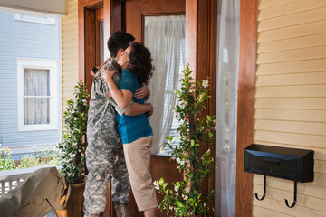Hispanic mother greeting soldier son