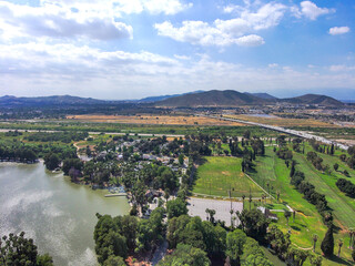stunning aerial shot of the the lake and lush purple and green trees surrounding Lake Evans at Fairmount Park in Riverside California USA