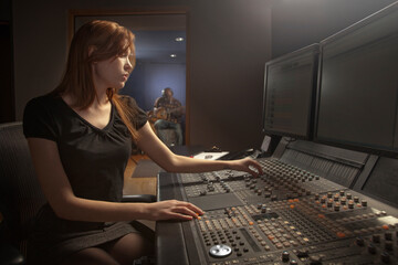 Caucasian woman working at audio control panel