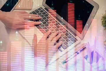 Multi exposure of woman hands typing on computer and forex chart hologram drawing. Stock market...