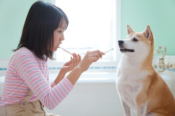 犬と一緒に歯みがきをする女の子