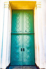 Grande retro green metal door. Doorway entry on building with Greek architecture design.