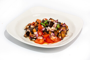 Fried eggplant salad with tomatoes and onions is on the plate