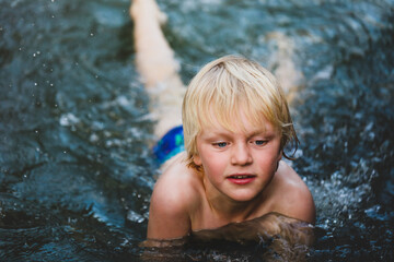 Obraz premium Boy swimming in natural swimming hole in central New South Wales, Australia