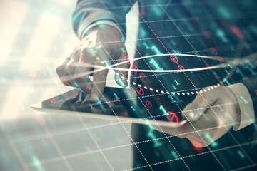 Double exposure of man's hands holding and using a digital device and forex graph drawing. Financial market concept.