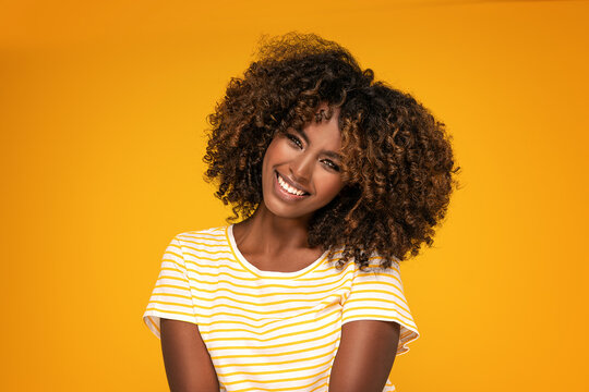 African afro woman with curly hair smiling.