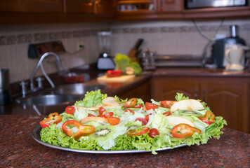 Comida saludable para una excelente calidad de vida, ensalada mixta, pimenton, lechuga, tomate cherry, kiwy, aguacate o palta, en meson de granito de la cocina a tu comedor