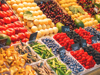 Fruit stand in the market. Sale of exotic and local fruits and berries-raspberries, blackberries, peaches, apricots, avocados.