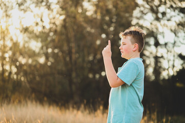 Boy playing in field at sunset