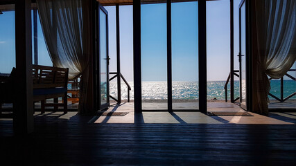 Beautiful sea view from the door of cafe interior on the beach in sunny summer day