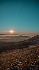 Mountain climbing, popular tourist attraction, impressive view, mountains are covered in fog, winter sunset, fantastic view. Dramatic wintry scene. Wallpaper for phone