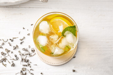 Glass of tasty cold ice tea on table