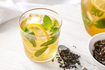 Glass of tasty cold ice tea on table