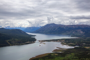 Naklejka premium Beautiful View of a small Touristic Town, Carcross, surounded by Canadian Mountain Landscape. Located near Whitehorse, Yukon, Canada.