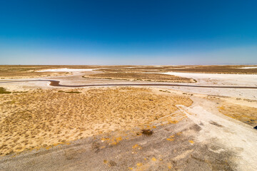 Salty lake coast. lake salt farm. The shore is covered with salt deposits on a white lake. Salt production area