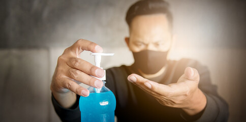 Hand of an Asian man Use a hand sanitizer gel pump. Rinse the cleansing gel From a clean pump bottle To kill germs, bacteria and viruses. COVID 19, Corona Virus, Protect Concept.
