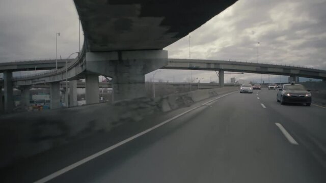 Montreal, QC, Canada - November 15, 2017: Vehicles on interchange road on the highway, filmed while driving fast with cloudy sky in the background.