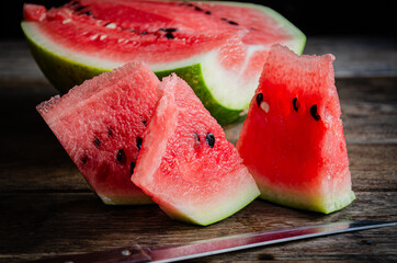 Ripe sliced watermelon on slices on a wooden table.