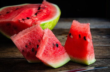 Ripe sliced watermelon on slices on a wooden table.