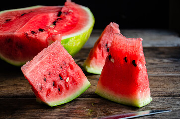 Ripe sliced watermelon on slices on a wooden table.